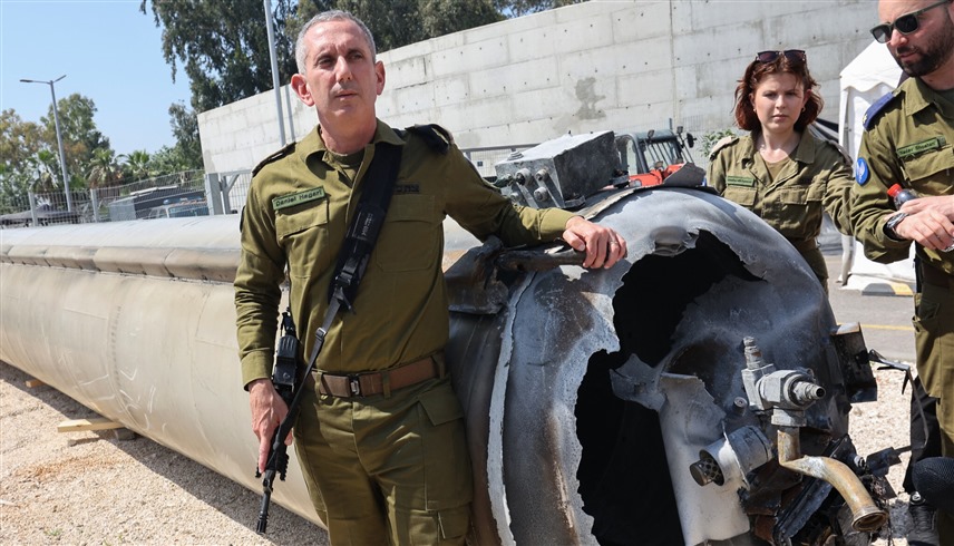 المتحدث باسم الجيش الإسرائيلي دانيال هاغاري أمام حطام لصاروخ إيران (أ ف ب)