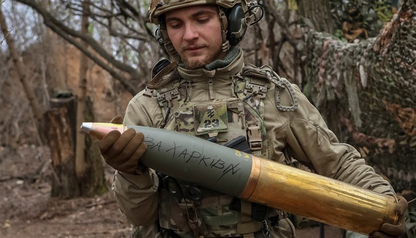 جندي أوكراني حاملاً قذيفة مدفعية (أرشيف)