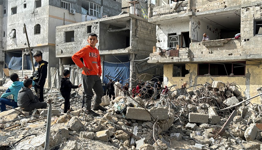 طفل فلسطيني واقف على أنقاض مبنى مدمر في رفح (أرشيف)