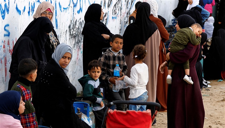 أطفال بصحبة ذويهم في قطاع غزة (رويترز)