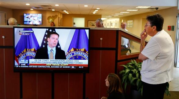 أمريكي يشاهد كومي أثناء أحد مؤتمراته الصحافية (أرشيف)