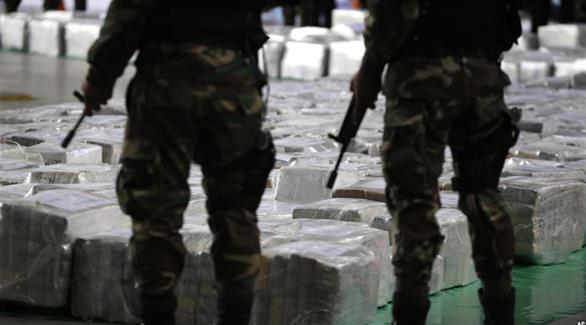 عنصران من الشرطة الكولومبية أمام مخدرات تم مصادرتها (أرشيف)