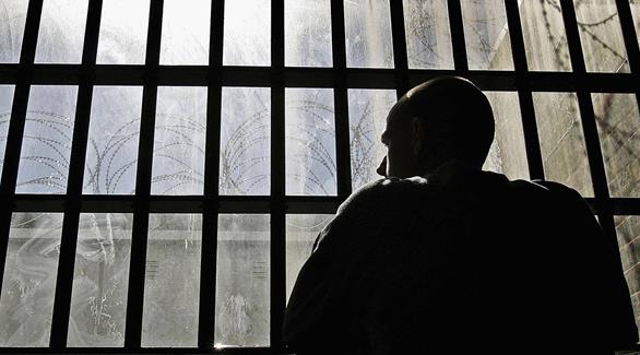 سجين ينظر إلى القضبان (أرشيف)