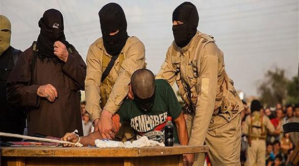ملثمون من داعش أثناء ارتكابهم جريمة ضد أحد المدنيين (أرشيف)
