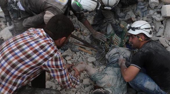مسعفون يحاولون إنقاذ أحد السوريين بعد قصف منزله(أرشيف)