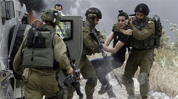 جنود إسرائيليون يعتقلون شاباً فلسطينياً (غيتي)