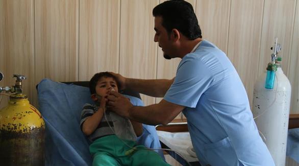 مسعف يقدم علاجاُ لطفل عراقي أصيب باختناق (أرشيف)