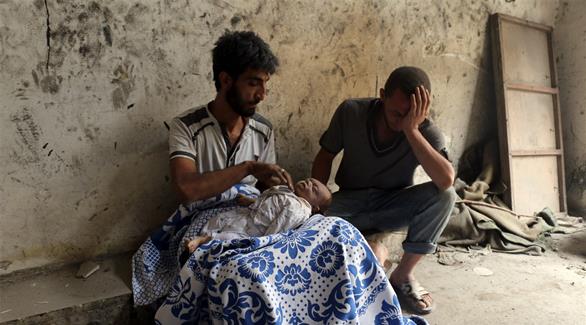 أب يحمل جثة رضيعه بعد قصف على حلب صباح اليوم (أ ف ب)