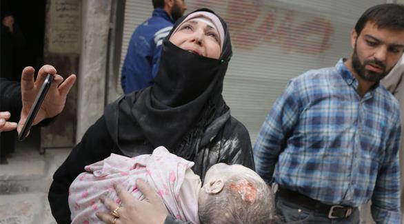امرأة سورية تحمل طفلتها الرضيعة التي قتلت جراء الضربات الجوية على مناطق المدنيين الواقعة تحت سيطرة المعارضة في حلب (أ ف ب)