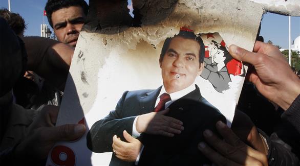 متظاهر يحمل صورة محروقة للرئيس السابق بن علي (أرشيف)
