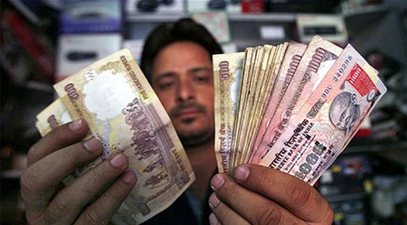 هندي يحمل عملات نقدية بفئاتها المتعددة (أرشيف)