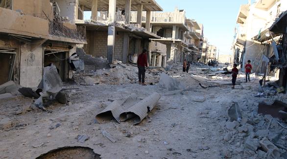 سوريون يتفقدون المواقع المتضررة بعد  غارات جوية على المتمردين في حي الشيخ فارس بحلب (رويترز)