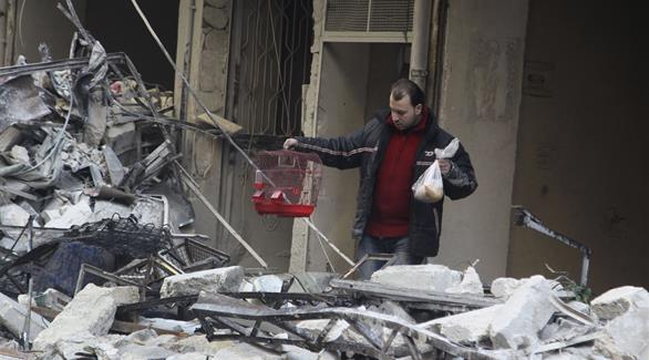 سوري ينقذ ما تبقى من منزله بعد غارات النظام عليه (أرشيف)