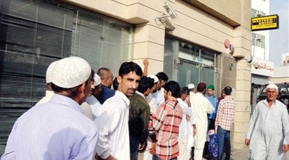 عمالة وافدة في السعودية أمام محل تحويل أموال إلى الخارج (أرشيف)