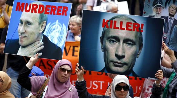 متظاهرون يحملون صورة الرئيس الروسي خلال تجمع في استراليا (أرشيف / رويترز)