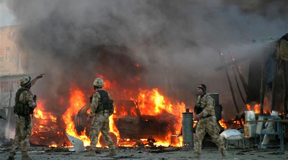 جنود بريطانيون بالقرب من سيارة محترقة في كابول عام 2005 (رويترز)