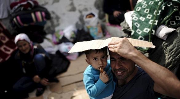 لاجئون سوريون ينتظرون على نقطة حدودية في تركيا(رويترز)