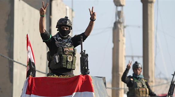 القوات العراقية ترفع العلم العراقي فوق ابنية منطقة تل اسود بعد تحريرها من داعش (أرشيف)