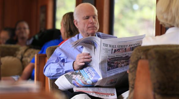ماكين يقرأ جريدة مع عنوان قوز ترامب بترشيح الجمهوريين (أرشيف)