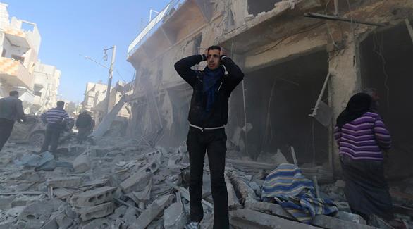 سوري يقف وسط الركام الذي خلفته غارات النظام السوري (رويترز)