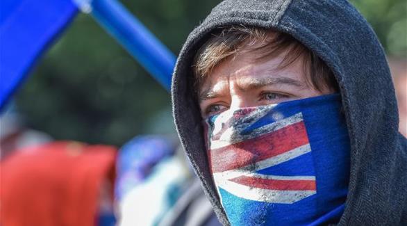 متظاهر يضع العلم الأسترالي على وجهه في ميلبورن (نيوز كورب استراليا)
