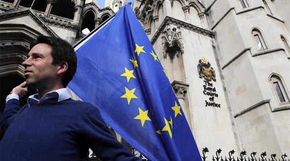رجل يحمل علم الاتحاد الأوروبي أمام مقر المحكمة البريطانية العليا (أ ف ب)