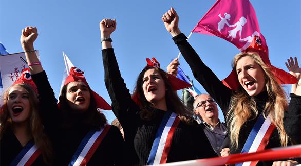 متظاهرات يرتدين رمز الجمهورية الفرنسية خلال التظاهرة في باريس (أ ف ب)