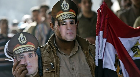 مصري يرتدي قناعاً بوجه وزير الدفاع المصري عبد الفتاح السيسي(أ ف ب)