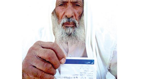 مسن العيص يحمل بطاقته البنكية (الوطن)