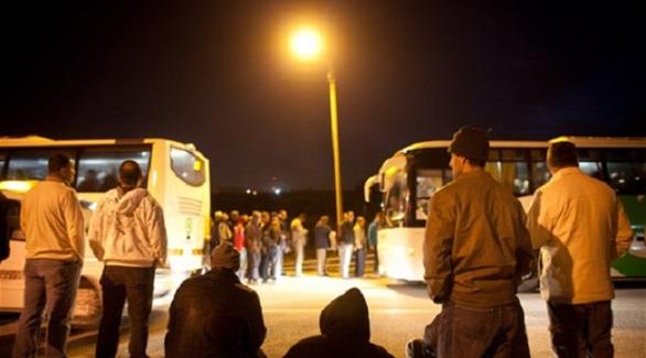 عمال فلسطينيون يتنظرون الحافلات (أرشيف)