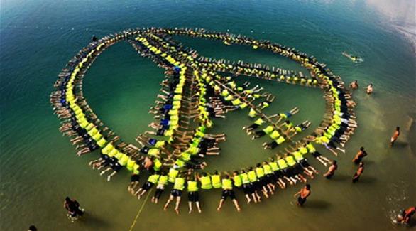 شكل المتطوعون سلسلة بشرية من 261 شخصاً على شكل إشارة السلام في البحر الميت (وكالة عمون الأردنية)
