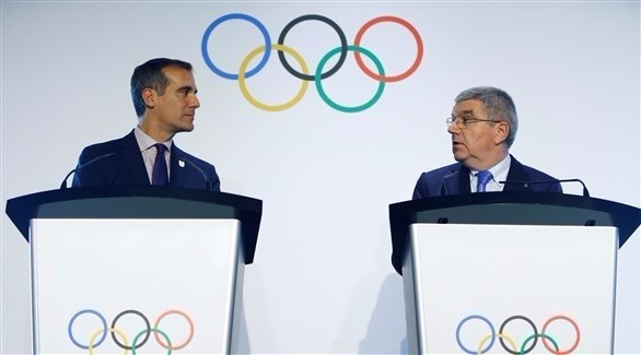 عمدة مدينة لوس أنجليس إيريك غارسيتي ورئيس اللجنة الأولمبية توماس باخ (رويترز)