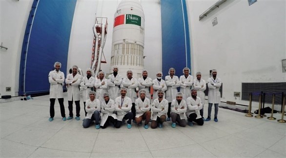 فريق القمر الصناعي السعودي أمام الصاروخ الذي سيحمل القمرين الصناعيين إلى الفضاء (هي)
