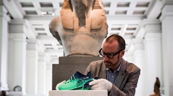 نيل سبنسر يضع حذاء محمد صلاح في المتحف البريطاني (تويتر)