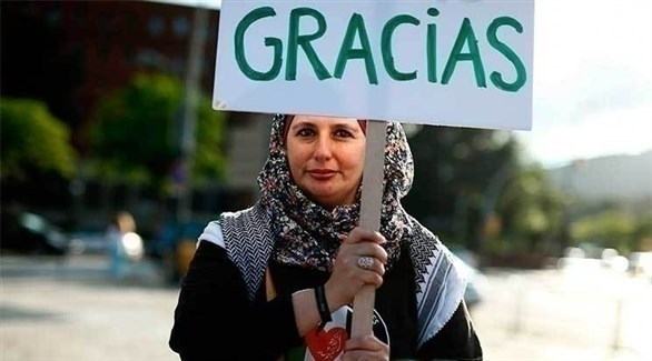 فلسطينية تحمل لافتة كتبت عبارة عليها باللغة الإسبانية تقول "شكراً"  (يورو نيوز)