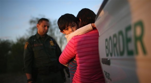 شرطي ينظر إلى الأطفال على الحدود الأمريكية (غيتي)