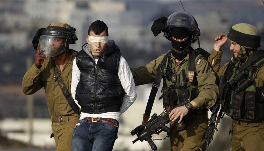 أفراد من الجيش الإسرائيلي يعتقلون فلسطينياً في وقت سابق (أ ف ب)