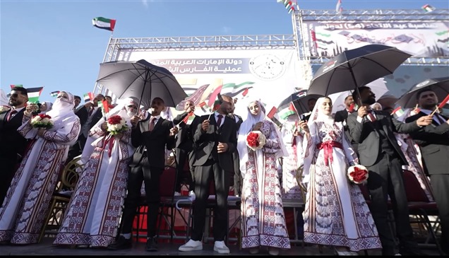 شاهد| تزامناً مع عيد الاتحاد.. الإمارات تنظم زفافاً جماعياً لـ54 عريساً في غزة