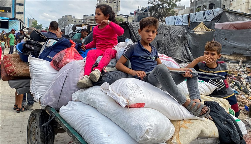 أطفال فلسطينيون نازحون أثناء فرارهم من مناطق في شمال قطاع غزة  (رويترز)