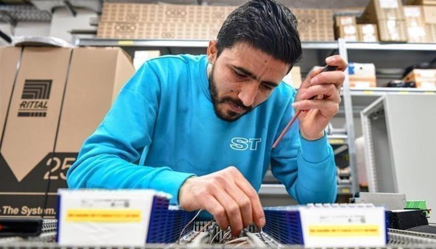 عامل سوري خلال عمله في أحد المصانع بألمانيا (رويترز)