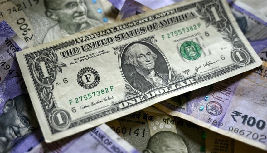 ورقة نقدية من الدولار الأمريكي فوق أوراق نقدية من الروبية الهندية (أ ف ب)