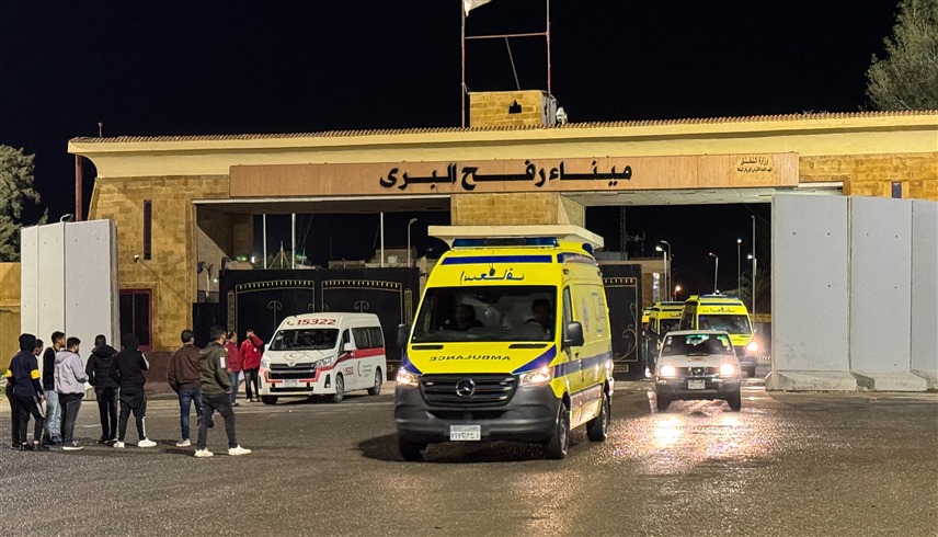 سيارات إسعاف تقل فلسطينيين تعبر إلى الجانب المصري من معبر رفح (أ ف ب)