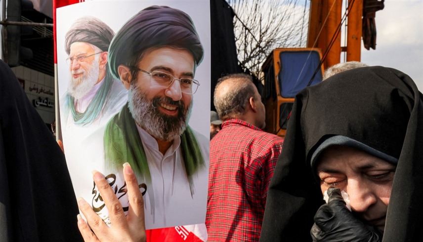 إيرانيون يرفعون صورة مجتبى ووالده علي خامنئي (أ ف ب)