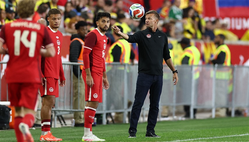 جيسي مارش مع لاعبي منتخب كندا (أ ف ب)