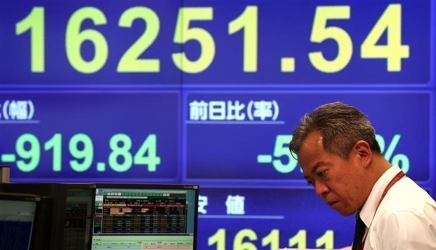 موظف يتابع مؤشر "نيكي" في بورصة طوكيو (AFP)