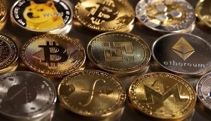 قطع معدنية تحمل شعارات للعملات المشفرة (رويترز)