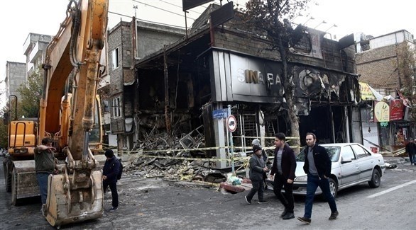 إيرانيون أمام مصرف أحرقه محتجون (أرشيف)