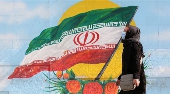 ‘إيرانية تسير بجانب جدارية لعلم بلادها (أرشيف)