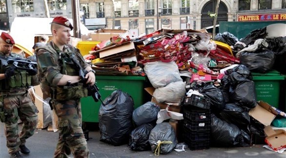 جنديان يمران بجانب كومة من النفايات في فرنسا (أرشيف)