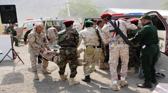 عناصر من الجيش اليمني ينقلون مصابين في الهجوم الصاروخي إلى سيارة إسعاف (تويتر)